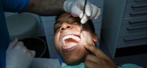 A patient points to the area of the tooth that may need to be be extracted.
