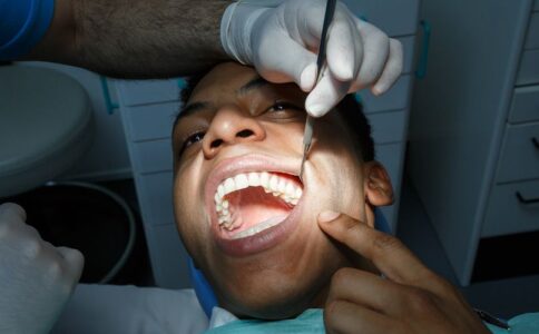 A patient points to the area of the tooth that may need to be be extracted.