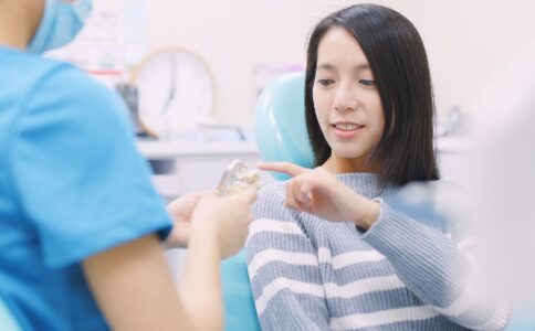 A patient pointing to a place with an implant on an educational figure, asking a question.