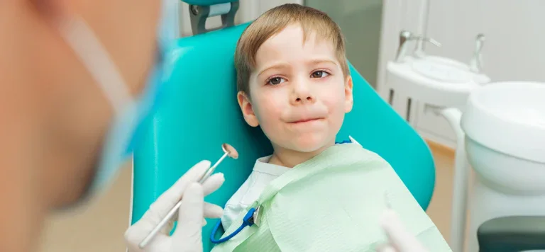 Img Managing Anxiety During Tooth Extractions Young Boy In Dental Chair Smiling At Camera During Tooth Extraction Consultation.