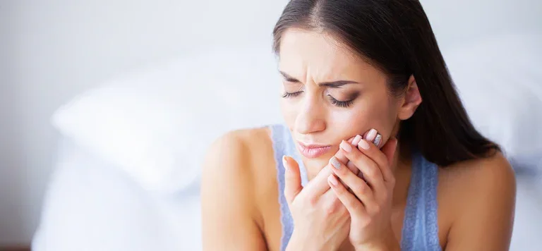 Img What To Do Break Tooth On Weekend Woman With Tooth Pain Holding Her Cheek, Seeking Emergency Dental Care.